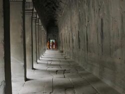 WS Buddhist monks walk down a pillared corridor in an ancient temple in Angkor Wat / Siem Reap, Cambodia Stock Footage