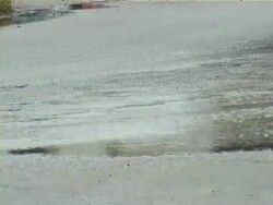 Wheels over a road puddle Stock Footage