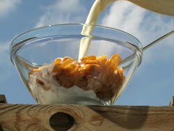 milk pouring in a bowl of muesli Stock Footage