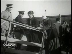 1938: TANGIER (TANGIERS), MOROCCO: DEPORTATION:  Military men & civilians standing near barricade. Officers supervising men boarding ship ramp (statute against Communists). WS Men at ship's railing gesturing w/ raised fists. Instructional Video