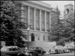 1949: WHITE PLAINS PARKING AUTHORITY: HA WS Buildings, street, cars, White Plains, New York. WS Parking Authority building (unconfirmed). INT VS Parking Authority members in meeting, looking over map. MS Head of table pointing to map. Instructional Video