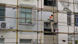 Workers paint the wall of an old residential building Stock Footage