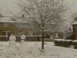 Zoom in to two large snowmen, United Kingdom Stock Footage