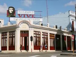MS Shot of Che billboard on building with traffic and Pedestrians / Cuba Stock Footage