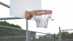 Basketball going into outdoor basketball hoop. Stock Footage