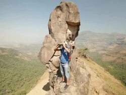 Young man standing on a cliff of mountain and looking through a binocular  Stock Footage