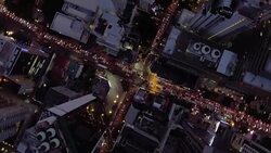 Aerial night vertical view of skyscraper rooftops and illuminated streets in a modern city Stock Footage
