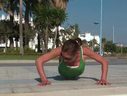 MS Lady doing push up for fitness in garden at beach / San Pedro Alcantara, Malaga, Spain Stock Footage