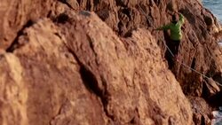 Man traverses highline stretched above sea below Stock Footage