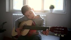 Boy playing guitar at home Stock Footage