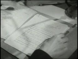 Hands flip through a dossier. News Clip