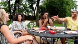 MS PAN Laughing group of friends hanging out in backyard on summer evening Stock Footage