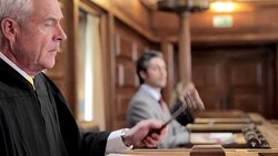 Judge banging gavel at bench in courtroom Stock Footage
