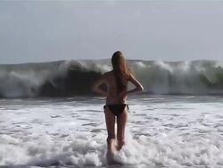 MS Teenage girl walking into sea big breaking waves / Seminyak, Bali, Indonesia Stock Footage