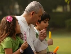Senior man eating ice cream with his grandchildren in a park  Stock Footage