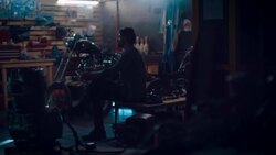 Man sitting in motorcycle workshop drinking coffe Stock Footage