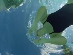MS SLO MO Woman swimming in pool, underwater shot taken from below looking up. Stock Footage