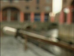 Liverpool, Tate Liverpool Pan across Albert Dock to Tate entrance. Entrance from opposite side of dock, boat in foreground. Tate entrance; 2004; short sequence. Stock Footage
