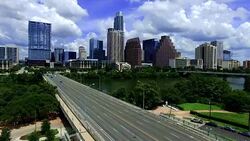 Aerial: Over Town Lake with Congress Avenue Bridge spanning Colorado River with Downtown Skyline Stock Footage
