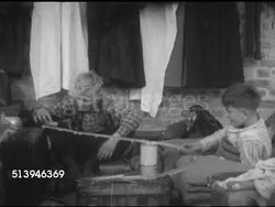 1953: REFUGEES: BERLIN, GERMANY: VS East Berlin refugees in camp, female writing, young boys playing w/ toy trains & rails, female sewing, male sleeping. Berlin Wall, occupied city Instructional Video