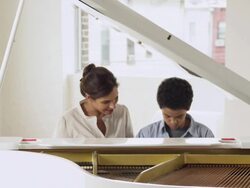 Boy and teacher at piano Stock Footage