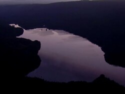 Mountain lake reflecting a golden sunset Stock Footage