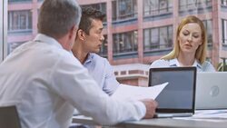 Two men and a woman in meeting about their project Stock Footage