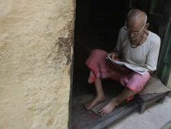 WS HA Man sitting in doorway reading newspaper / Varanasi, India Stock Footage