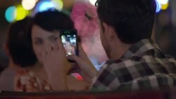 Young man takes a photo of his girlfriend before she pushes his smartphone away Stock Footage