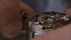 A hand holds the winding key of a clock mechanism. Stock Footage