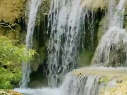 MS SLO MO Shot of water falling on brown rocks and shrub / Kuang Si, Luang Prabang, Laos Stock Footage