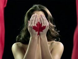 Woman with red maple leaf painted on hands, head in hands Stock Footage