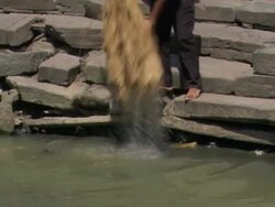 WS TU PAN Men wetting straw in Bagmati river for funeral pyre / Kathmandu, Central Region, Nepal Stock Footage
