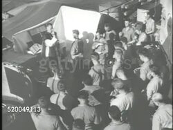 1945: UNITED STATES TROOP CHAPLAIN: LA WS Flags flying on ship, including US flag. VS Troop Chaplain saying final prayers & blessing w/ US Marines on deck of ship, handing out bread for Holy Communion, aka Eucharist. WWII, Japan, invasion, religion Instructional Video