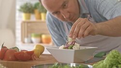 Man decorating vegetable salad with sprouts Stock Footage
