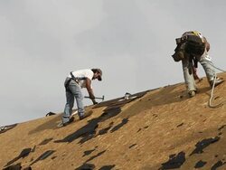 MS Two workers removing nails at top of roof / Chelsea, Michigan, United States Stock Footage