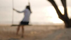 HD:Blurred Woman on swing on the beach with sea at sunset time , slow motion , relaxation concept Stock Footage