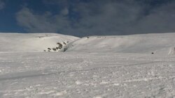 A skier races down the side of a snowy slope. Stock Footage