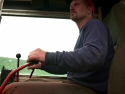 Medium profile shot of man operating skidder. Stock Footage