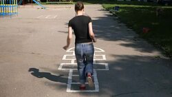 Slow motion shot of a girl playing hopscotch outdoors Stock Footage
