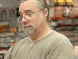 CU PAN middle aged customer in record store browses vinyl records by taking them out of the rack and looking at front and back of record / Palm Desert, California, USA Stock Footage
