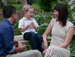 MS TU mother and father sitting with son at outdoor picnic table in discussion  Stock Footage
