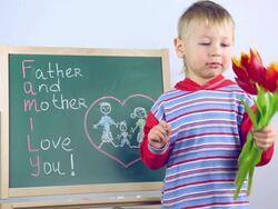 boy draws a card for parents on board Stock Footage