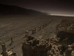 High Angle pan-left - A camel train crosses a desert after leaving the salt flats in Djibouti. / Djibouti Stock Footage