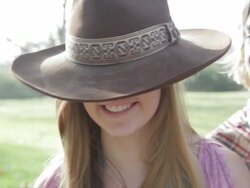 CU Boy putting large cowboy hat on girls head / Los Angeles, California, United States  Stock Footage