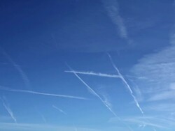 WS PAN T/L View of Many airplane vapour trails on blue sky bright sunny day with minimal wispy cloud / London, Greater London, United Kingdom Stock Footage