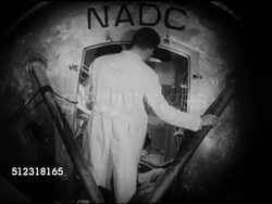 1953: NAVAL AIR DEVELOPMENT CENTER, JOHNSVILLE (NADC): CENTRIFUGE: Men in lab coats helping man out of machine cabin, unstrapping, Instructional Video