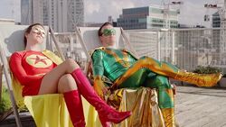 Superhero couple sunbathing on city rooftop Stock Footage