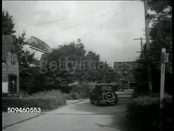 1938: NEW SAFETY DESIGN: 'Local' neighborhood traffic car driving road behind property. WS Heavy 'Through' traffic on highway bypassing town. Instructional Video