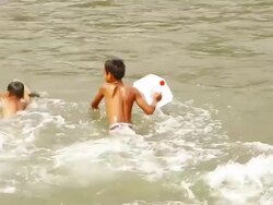 MS TS SLO MO Shot of two boys jumping into water with jeery cans / Ou river, Luang Prabang, Laos Stock Footage